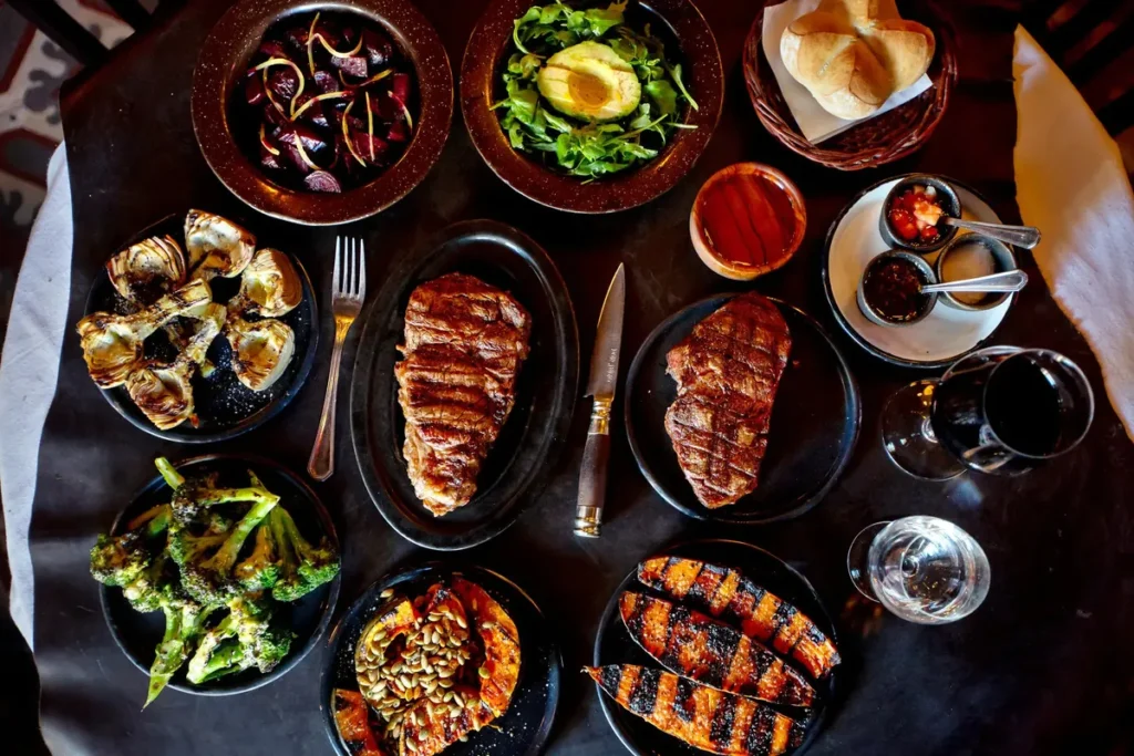 Table spread with grilled steaks and roasted vegetables in Buenos Aires