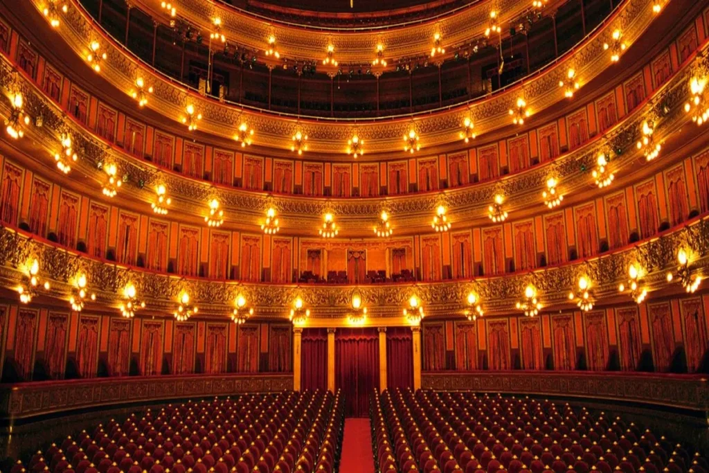 Interior view of the majestic Teatro Colón opera house in Buenos Aires showing golden balconies and red velvet seats