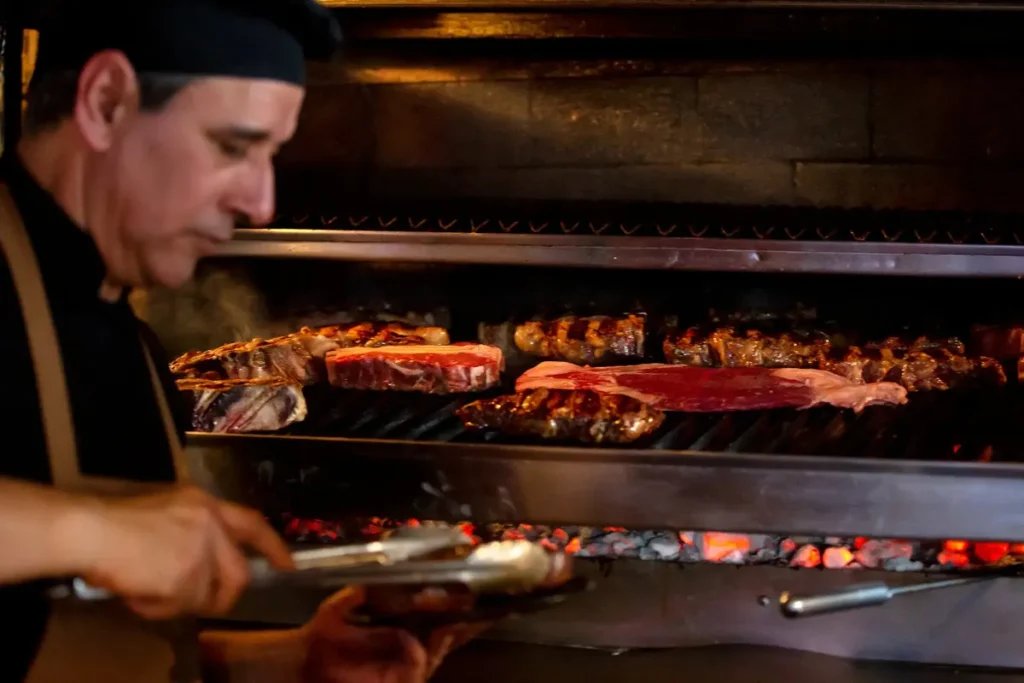 Chef grilling meats on a parrilla in Buenos Aires