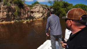 Angler casting fly line towards the steep earthen banks of the Corrientes river structure