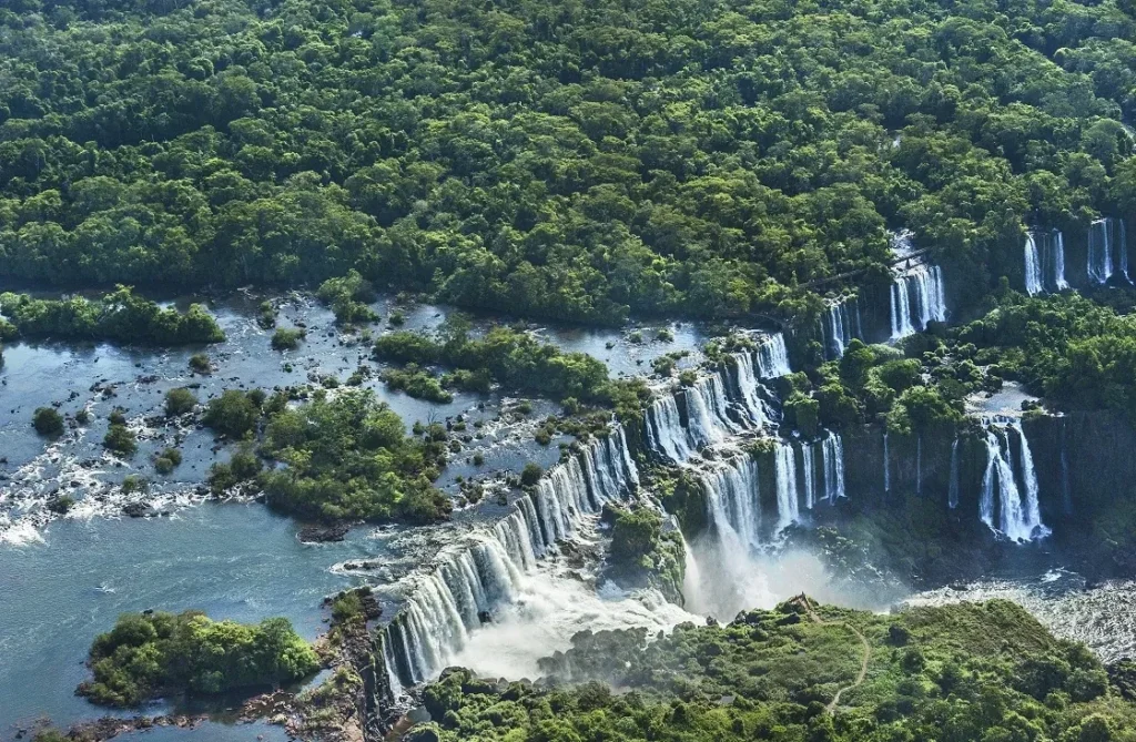 High-angle aerial view capturing the vastness of the Iguazu Falls system and surrounding rainforest