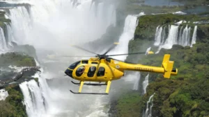 Yellow helicopter flying over the majestic Iguazu Falls for an aerial tour