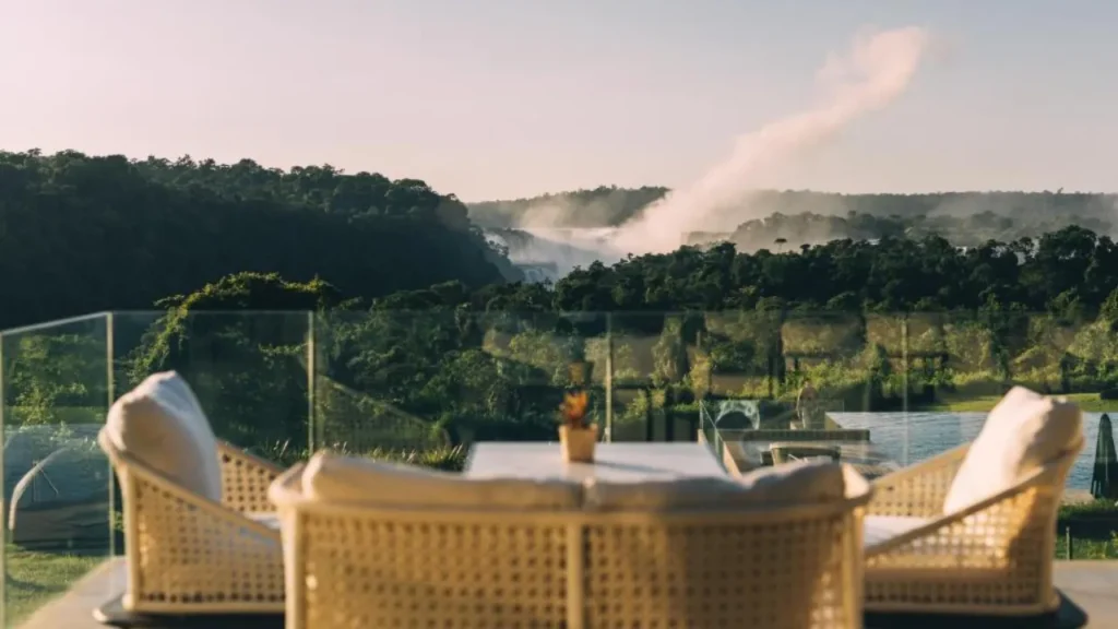 View from a luxury hotel terrace overlooking the lush jungle and Iguazu Falls in the distance