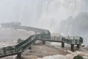 Iron walkways leading to the Devil's Throat fall over turbulent muddy waters during high water levels