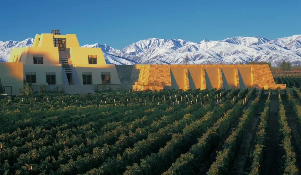 The iconic Mayan pyramid architecture of Bodega Catena Zapata surrounded by vineyards and the Andes mountains