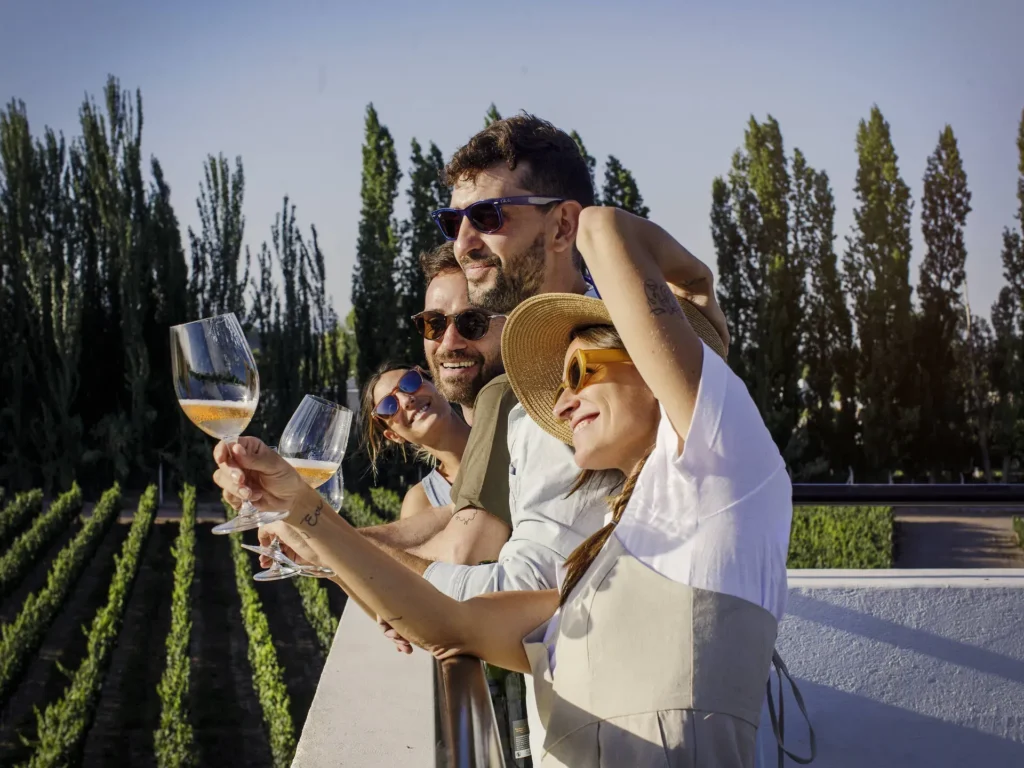 Friends enjoying white wine and laughter on a terrace overlooking the Mendoza vineyards